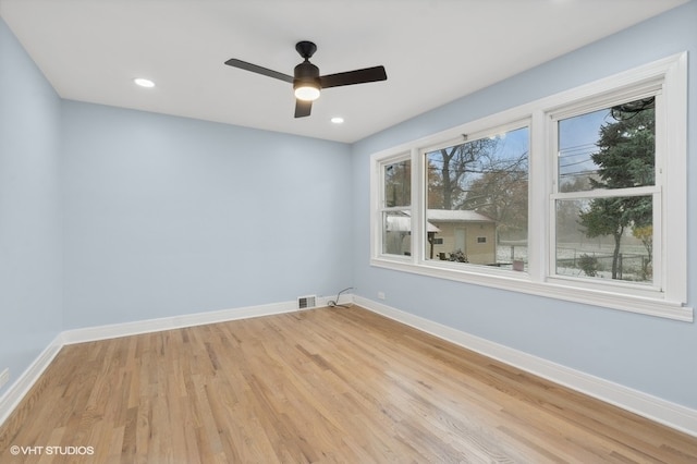 spare room featuring ceiling fan, a healthy amount of sunlight, and light hardwood / wood-style flooring