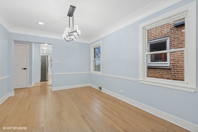 empty room featuring crown molding and light hardwood / wood-style flooring