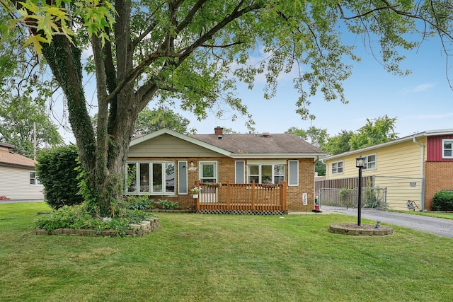 ranch-style house with a deck and a front yard