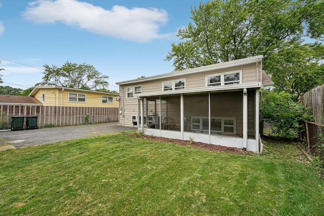 back of house featuring a sunroom and a yard