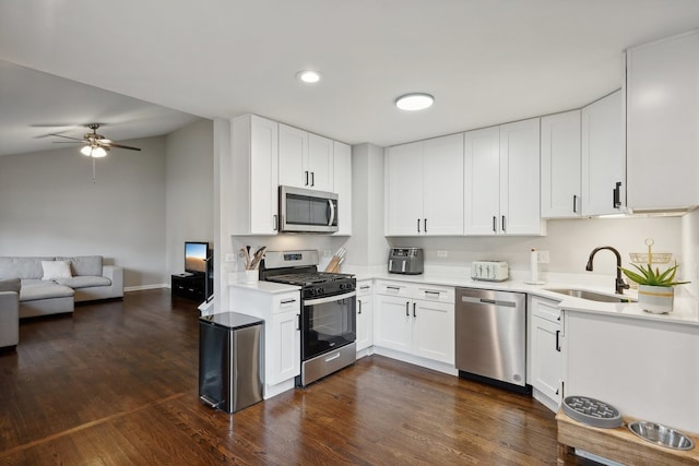 kitchen with dark wood-type flooring, sink, ceiling fan, appliances with stainless steel finishes, and white cabinetry