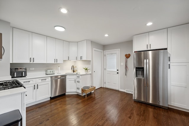 kitchen with white cabinetry, dark hardwood / wood-style flooring, stainless steel appliances, and sink