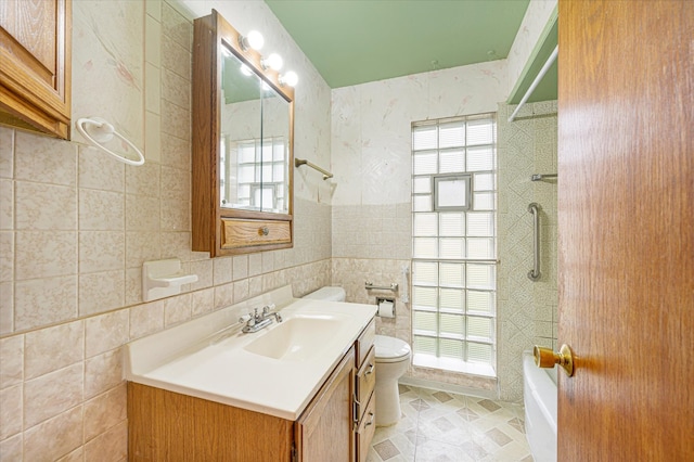 full bathroom featuring vanity, toilet, tile walls, and a wealth of natural light