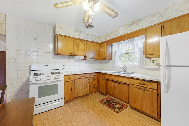 kitchen with white appliances, sink, ceiling fan, light wood-type flooring, and tasteful backsplash