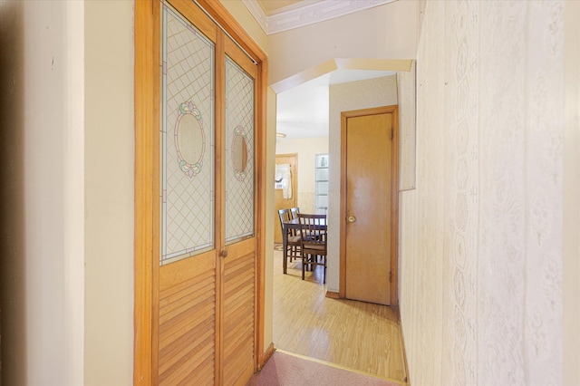 corridor with hardwood / wood-style floors and ornamental molding