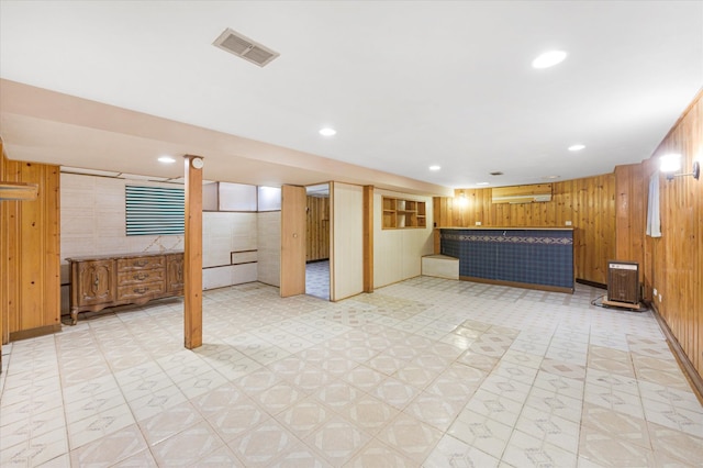 basement featuring an AC wall unit and wood walls