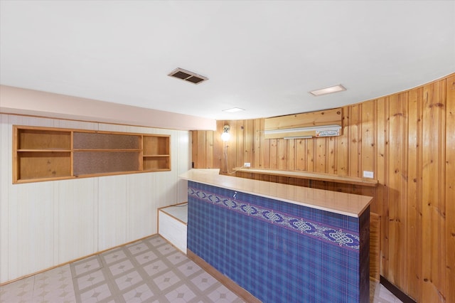 bar featuring built in shelves and wood walls