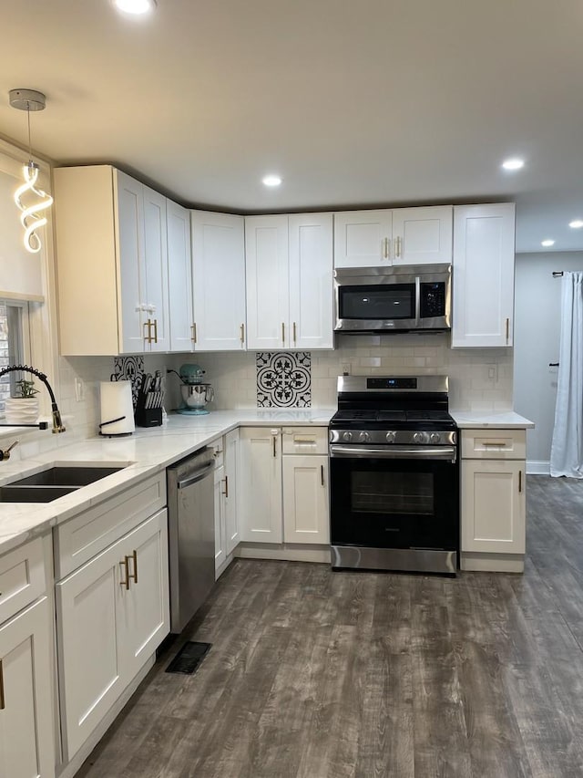 kitchen featuring pendant lighting, white cabinets, sink, and stainless steel appliances