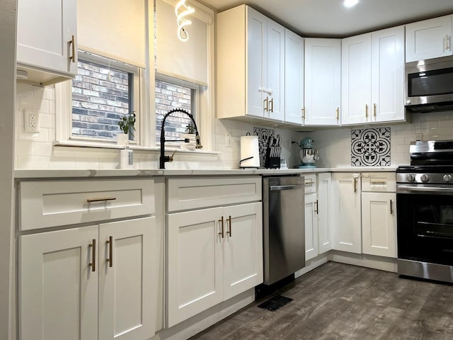 kitchen with backsplash, white cabinets, stainless steel appliances, and dark hardwood / wood-style floors