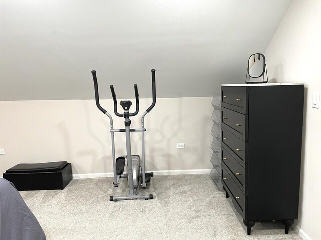 exercise area featuring light carpet and vaulted ceiling