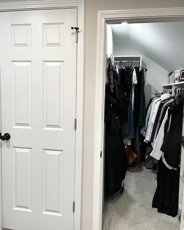 spacious closet featuring carpet floors and vaulted ceiling