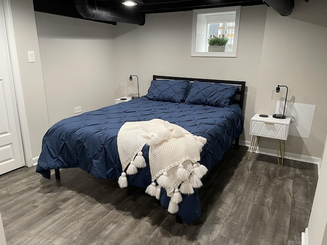 bedroom with dark hardwood / wood-style flooring