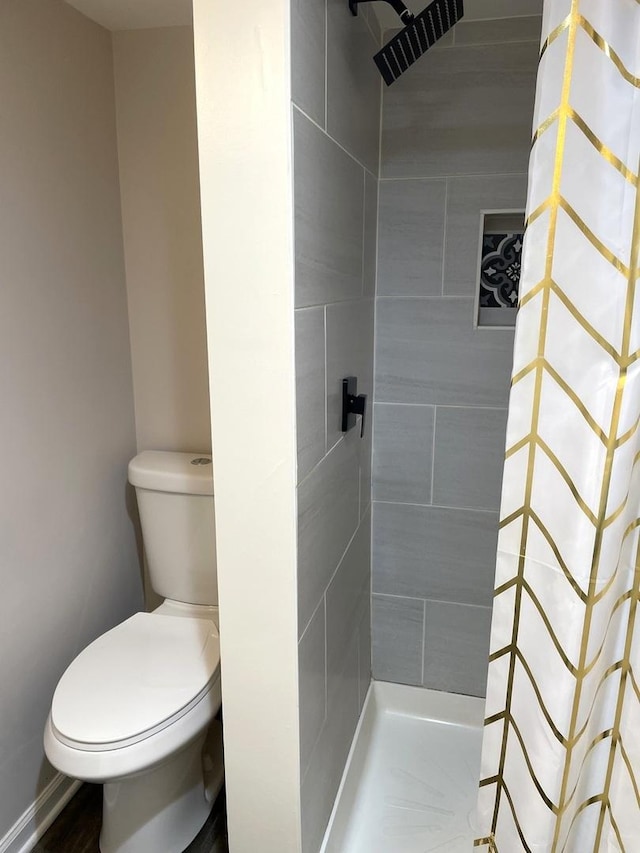 bathroom with tiled shower and toilet