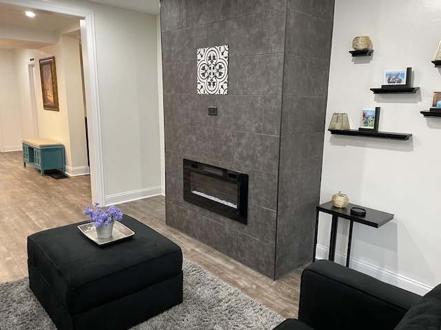 living room featuring hardwood / wood-style floors and a tile fireplace