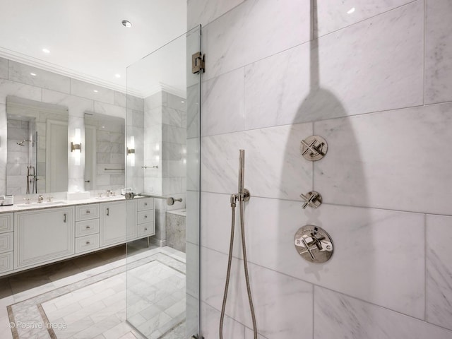 bathroom with ornamental molding, vanity, tile walls, and a tile shower