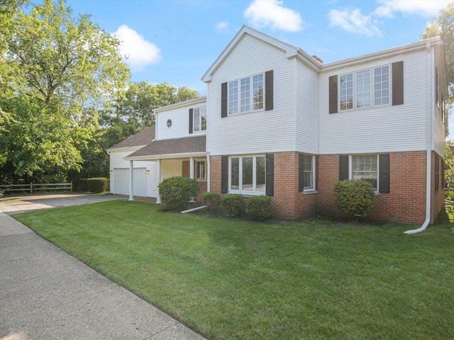 traditional-style house with brick siding, driveway, an attached garage, and a front yard