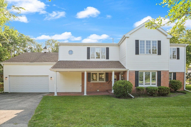 traditional-style home with a porch, a front lawn, a garage, aphalt driveway, and brick siding