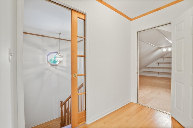 hallway with hardwood / wood-style flooring and ornamental molding