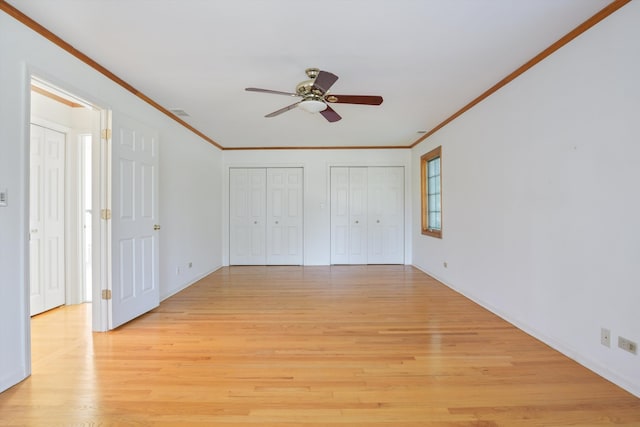 unfurnished bedroom with ceiling fan, multiple closets, ornamental molding, and light hardwood / wood-style flooring