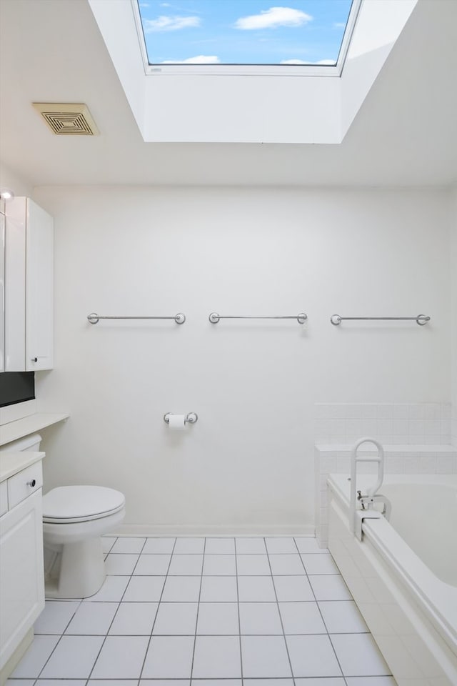 bathroom with vanity, a bathing tub, tile patterned floors, a skylight, and toilet