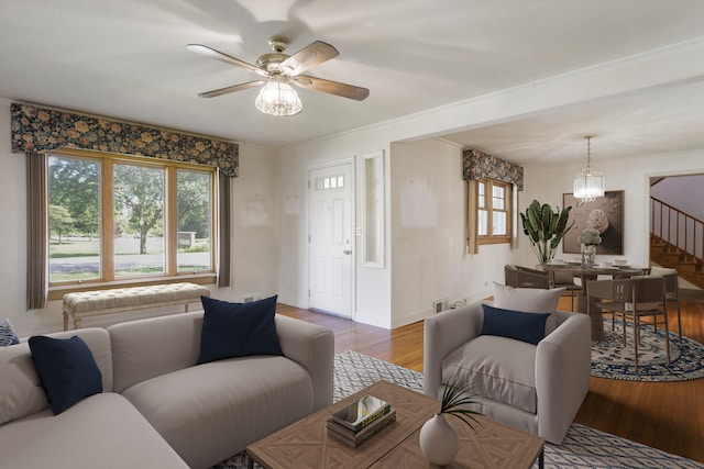 living room with hardwood / wood-style floors and ceiling fan with notable chandelier