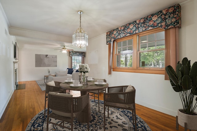 dining area with crown molding, ceiling fan with notable chandelier, and hardwood / wood-style flooring