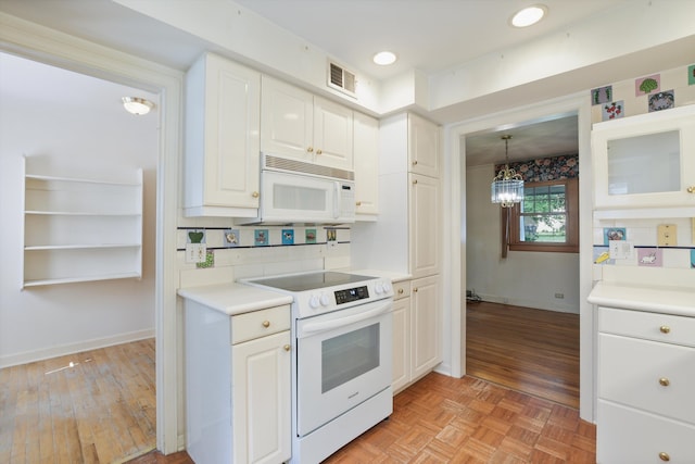 kitchen with white appliances, decorative light fixtures, white cabinetry, and light hardwood / wood-style floors