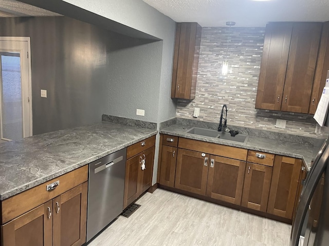 kitchen with tasteful backsplash, a textured ceiling, sink, dark stone countertops, and dishwasher