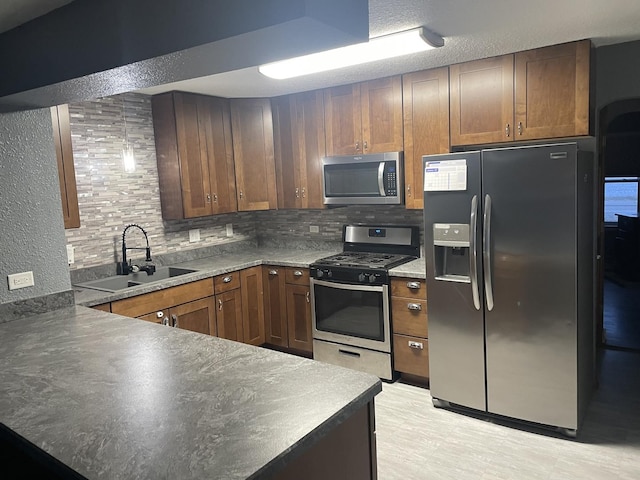 kitchen featuring decorative backsplash, sink, and appliances with stainless steel finishes