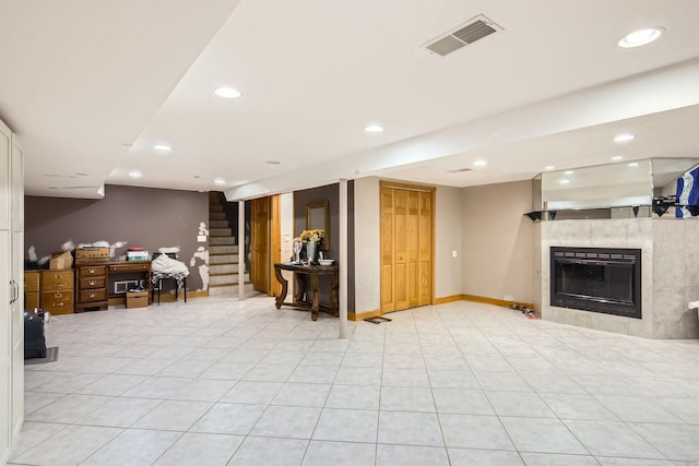 basement featuring a tile fireplace and light tile patterned floors