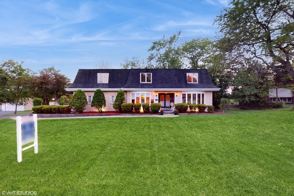 cape cod-style house with a front lawn