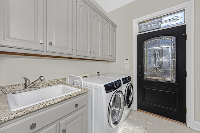 laundry area featuring cabinets, sink, washer and dryer, and light tile patterned floors