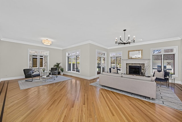 living room featuring crown molding, light hardwood / wood-style floors, and a notable chandelier