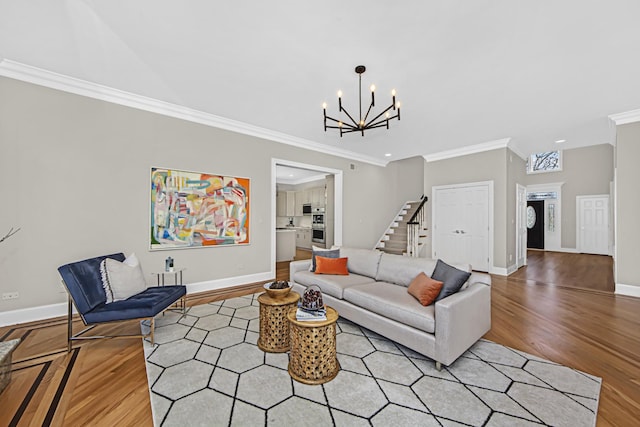 living room featuring an inviting chandelier, ornamental molding, and light hardwood / wood-style floors