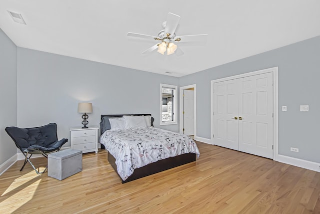 bedroom with ceiling fan, light hardwood / wood-style floors, and a closet