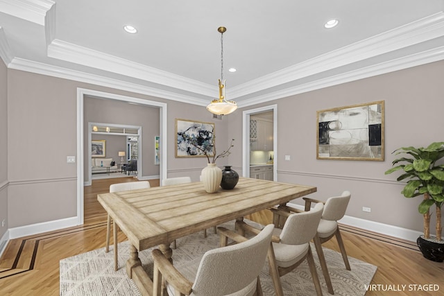 dining room with ornamental molding and light hardwood / wood-style floors