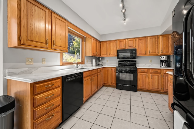 kitchen featuring light tile patterned flooring, sink, track lighting, and black appliances