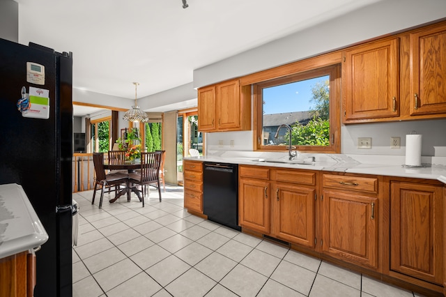 kitchen with sink, hanging light fixtures, an inviting chandelier, light tile patterned flooring, and black appliances