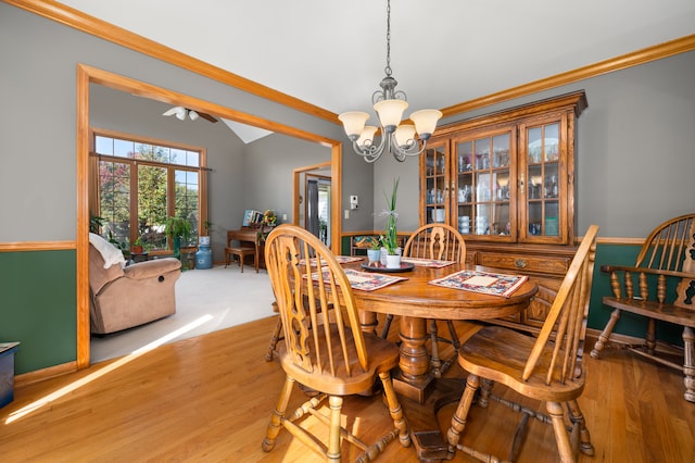 dining space with ceiling fan with notable chandelier, hardwood / wood-style flooring, and ornamental molding