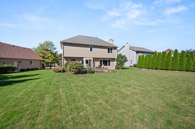 rear view of house featuring a yard