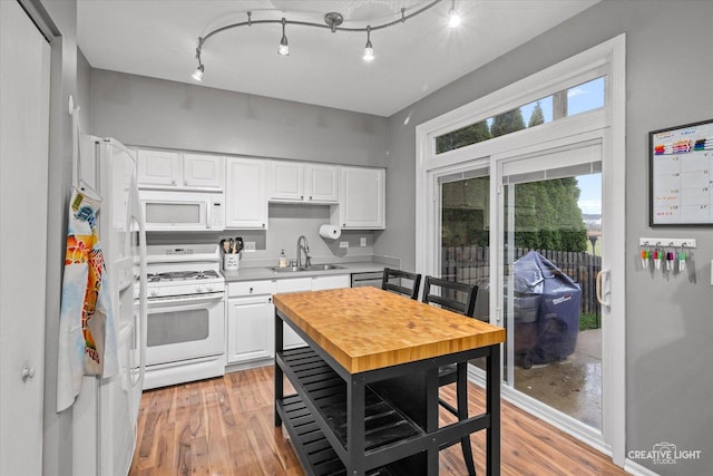 kitchen featuring white cabinetry, white appliances, and sink