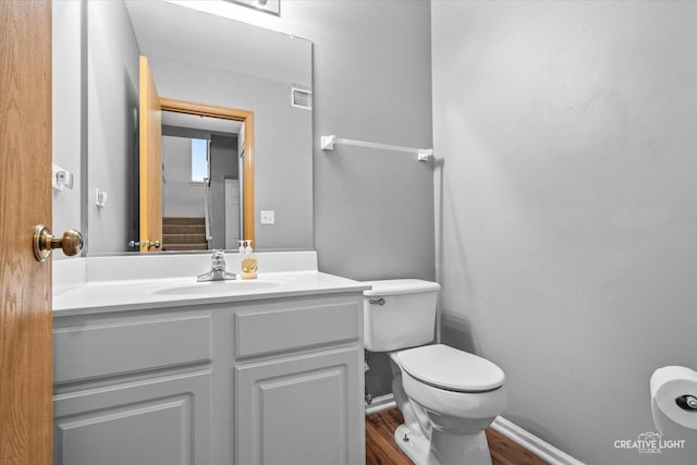 bathroom featuring vanity, hardwood / wood-style flooring, and toilet