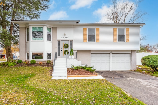 split foyer home with a garage and a front lawn