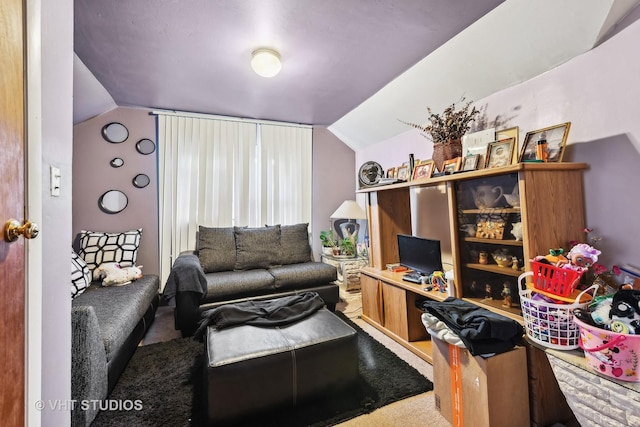 carpeted home office with vaulted ceiling