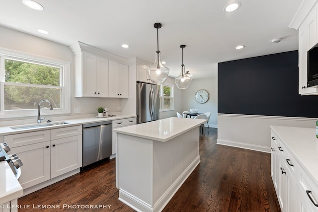 kitchen featuring sink, stainless steel appliances, a kitchen island, dark hardwood / wood-style flooring, and white cabinets