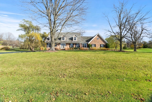 cape cod-style house featuring a front yard