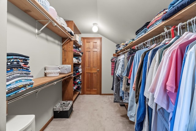 walk in closet featuring light colored carpet and vaulted ceiling