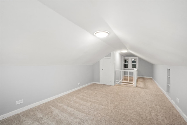 additional living space with light colored carpet and lofted ceiling