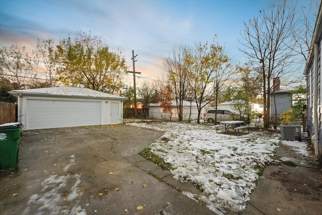 exterior space with cooling unit, a garage, and an outbuilding