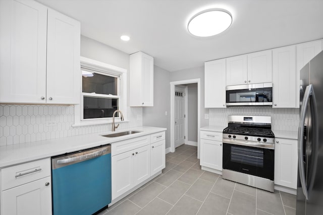 kitchen featuring white cabinets, appliances with stainless steel finishes, tasteful backsplash, and sink